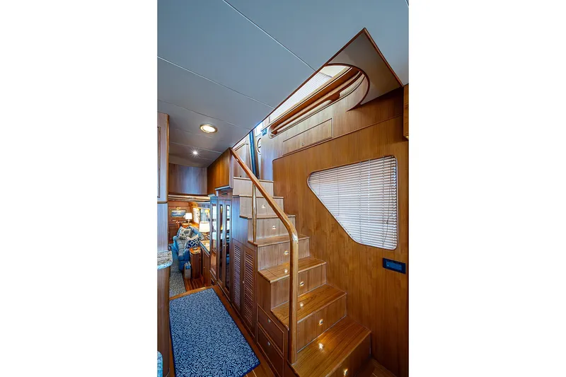 Slide: The Image of Interior of 2014 Marlow 80 Explorer yacht with wooden staircase and cozy seating area. - 35