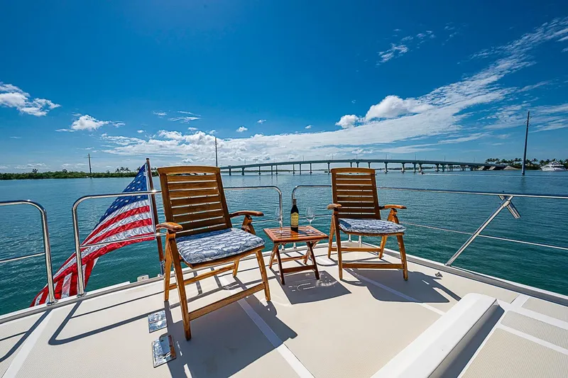 Slide: The Image of Deck of 2014 Marlow 80 Explorer yacht with chairs, table, and American flag. - 73