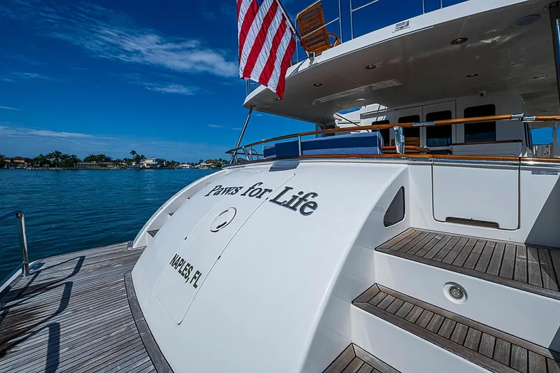 Slide: The Image of Luxury 2014 Marlow 80 Explorer yacht docked, featuring "Paws for Life" and American flag. - 82