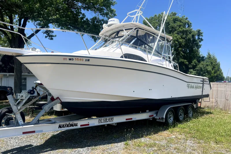 The Image of 2002 Grady-White Marlin 300 boat on trailer, parked outdoors. - 0