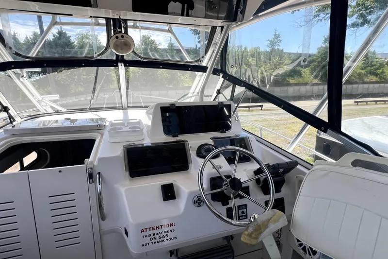 Slide: The Image of 2002 Grady-White Marlin 300 boat cockpit with steering wheel and navigation equipment. - 10