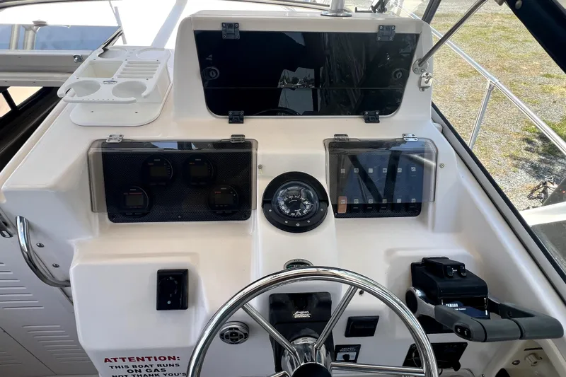 Slide: The Image of Control panel of a 2002 Grady-White Marlin 300 boat with steering wheel and gauges. - 11