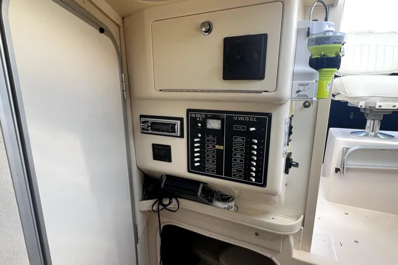 Slide: The Image of 2002 Grady-White Marlin 300 boat interior with electrical panel and seating area. - 13