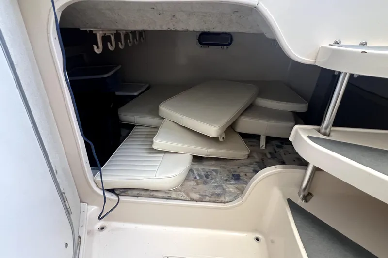 Slide: The Image of 2002 Grady-White Marlin 300 cabin interior with stacked cushions and storage hooks. - 14