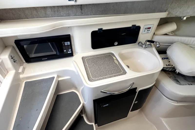 Slide: The Image of 2002 Grady-White Marlin 300 boat interior with kitchenette, sink, and microwave. - 15
