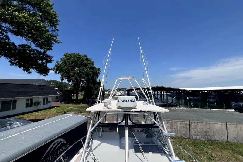Slide: The Image of 2002 Grady-White Marlin 300 boat docked, featuring Lowrance equipment, under clear blue sky. - 8