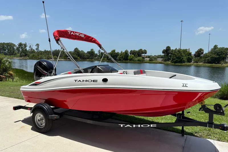 Slide: The Image of 2026 Tahoe T16 boat with red and white design, parked near a scenic lake. - 57