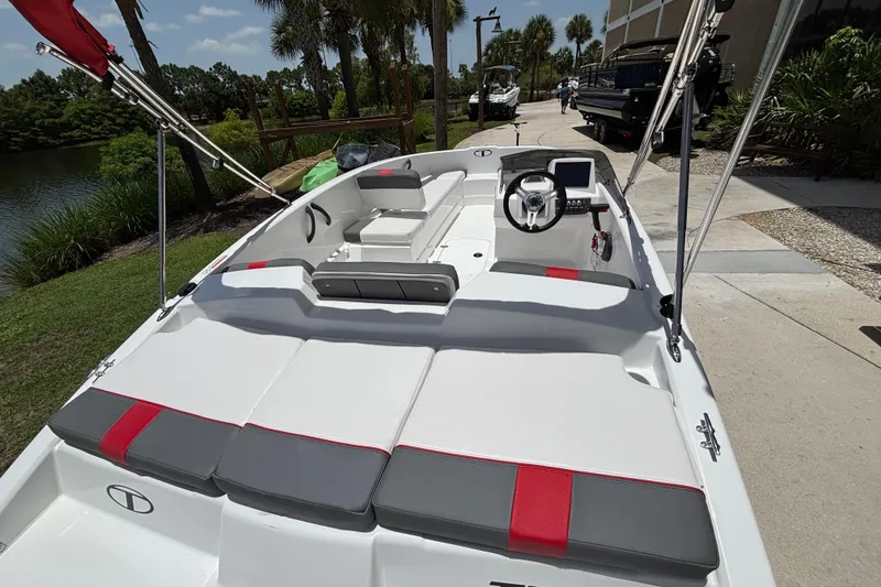 Slide: The Image of 2026 Tahoe T16 boat with sleek interior design, docked near lush greenery. - 61