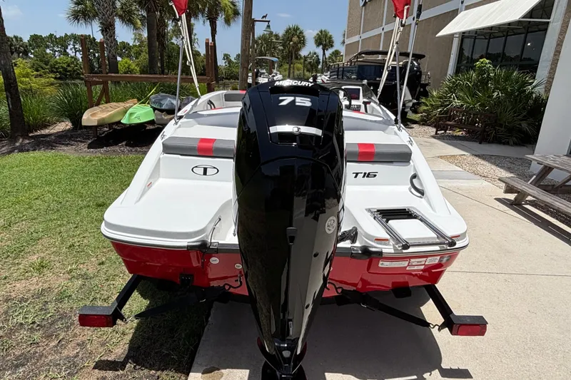 Slide: The Image of 2026 Tahoe T16 boat with Mercury 75 engine, parked outdoors near greenery. - 60