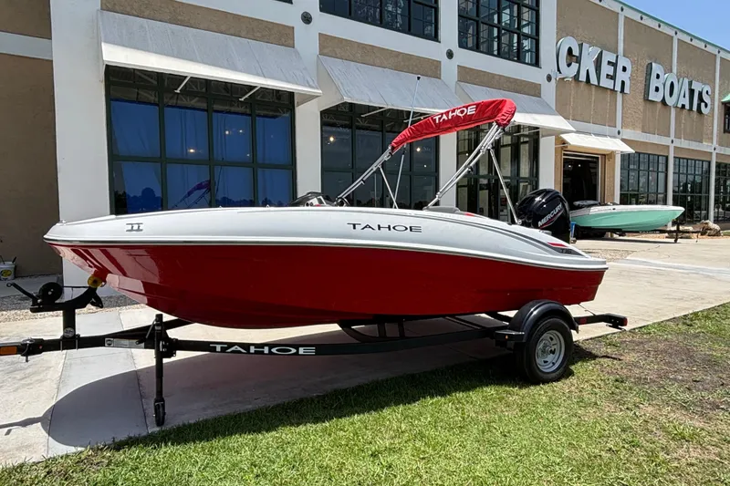 Slide: The Image of 2026 Tahoe T16 boat with red hull on trailer outside a boat dealership. - 59