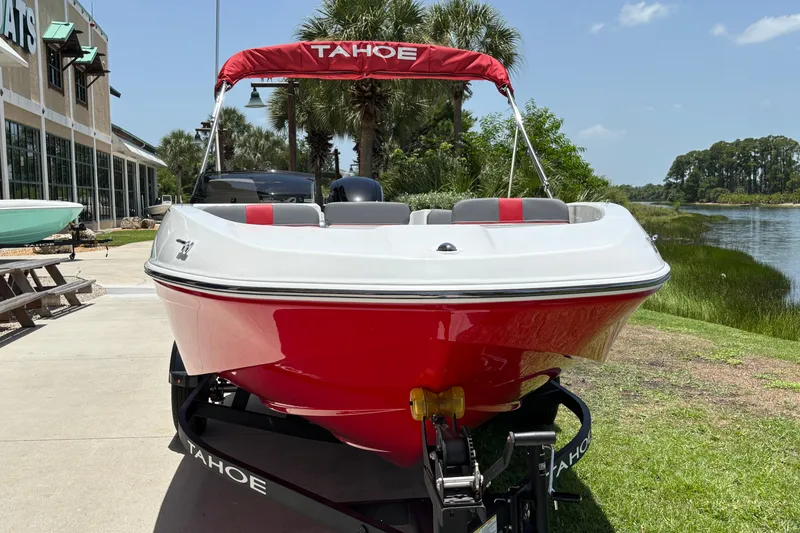 Slide: The Image of 2026 Tahoe T16 boat with red and white design, parked near a waterfront. - 58