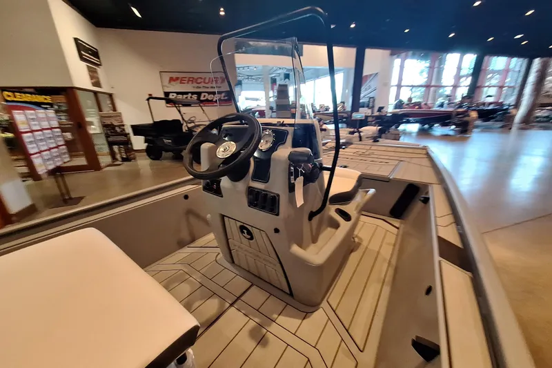 Slide: The Image of 2026 Tracker Bass Tracker Classic CC boat interior with steering console in showroom. - 2
