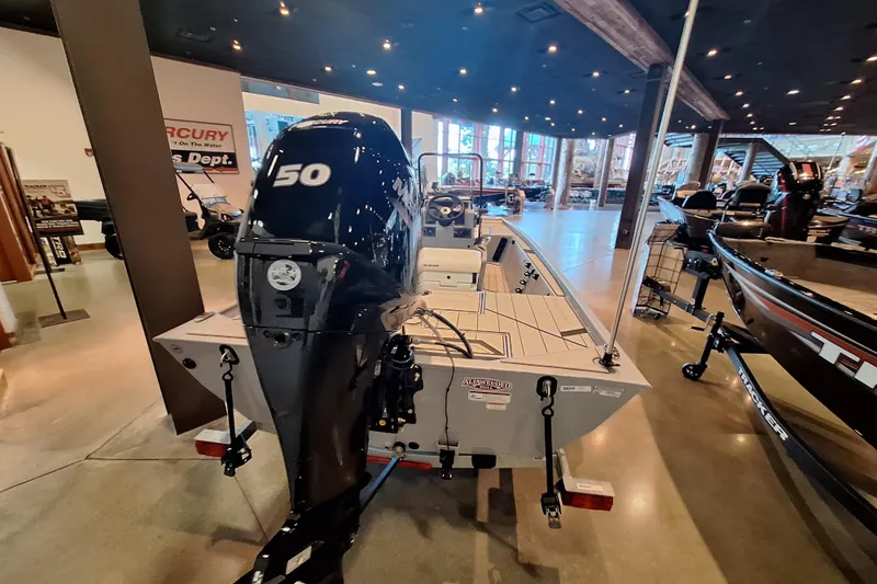 Slide: The Image of 2026 Tracker Bass Tracker Classic CC boat with 150 HP engine displayed indoors. - 6
