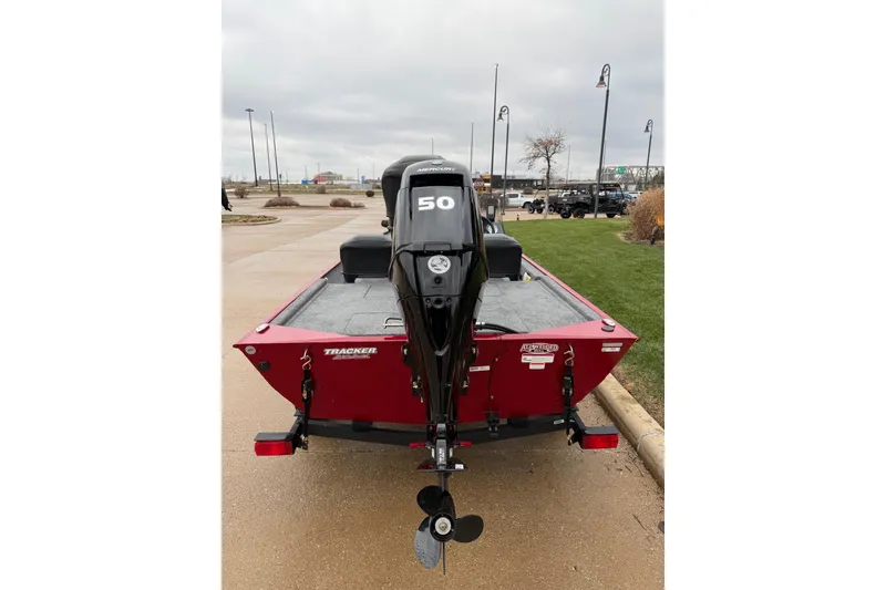 Slide: The Image of 2026 Tracker Bass Tracker Classic XL boat with a 50 HP Mercury engine, parked outdoors. - 2