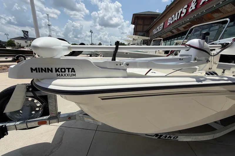 Slide: The Image of 2026 Mako Pro Skiff 15 CC with Minn Kota Maxxum trolling motor at a dealership. - 2