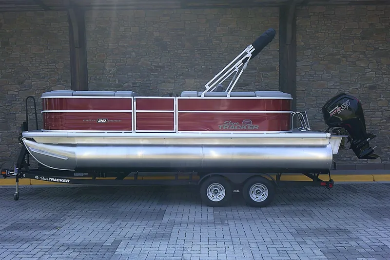 The Image of 2026 Sun Tracker Party Barge 20 DLX pontoon boat on trailer, parked outdoors. - 0