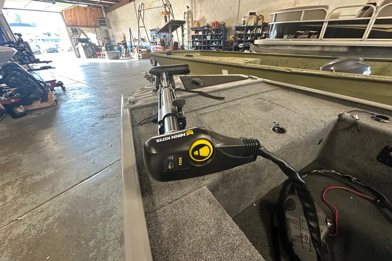 Slide: The Image of 2026 Tracker Grizzly 10 Jon boat with Minn Kota trolling motor in a workshop. - 30