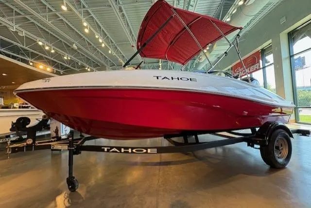 Slide: The Image of 2026 Tahoe T16 boat with red hull and canopy displayed indoors. - 1