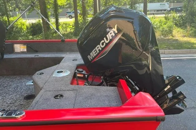 Slide: The Image of 2026 Tracker Pro Guide V-16 SC boat with Mercury outboard motor, parked outdoors. - 12