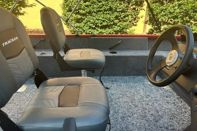 Slide: The Image of 2026 Tracker Pro Guide V-16 SC boat interior with gray seating and steering wheel. - 6