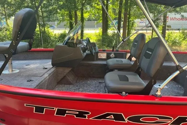 Slide: The Image of 2026 Tracker Pro Guide V-16 SC boat with red exterior and comfortable seating. - 9
