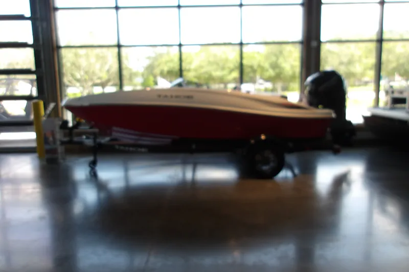 The Image of Blurry image of a 2026 Tahoe T16 boat on a trailer indoors. - 1