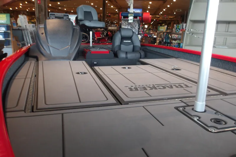 Slide: The Image of 2026 Tracker Savage 215 boat interior with seating and storage compartments in showroom. - 14
