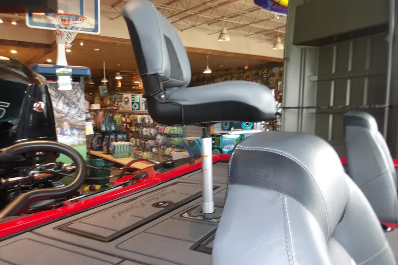 Slide: The Image of 2026 Tracker Savage 215 boat interior with gray seating in a showroom. - 18