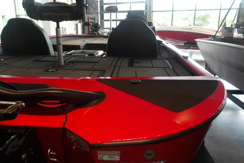 Slide: The Image of 2026 Tracker Savage 215 boat interior with red accents and seating in showroom. - 5