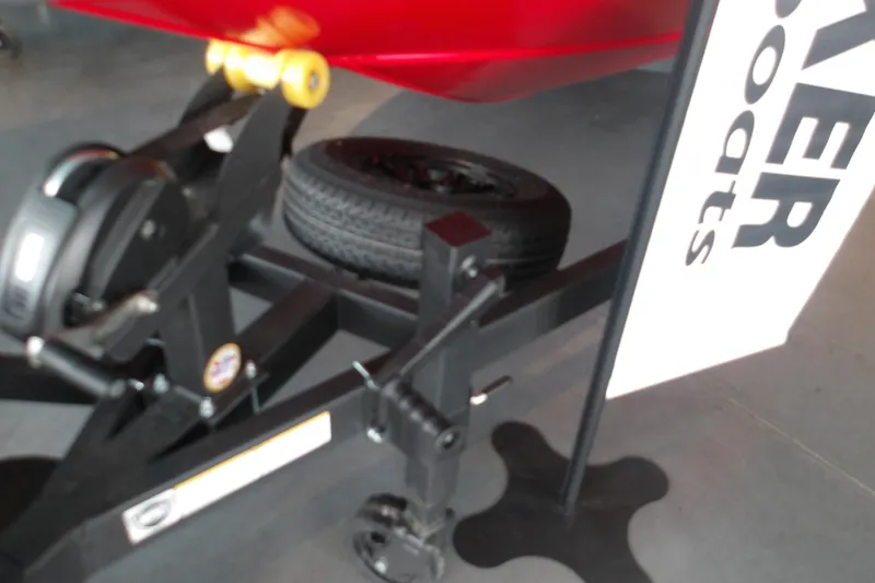 Slide: The Image of Trailer hitch of 2026 Tracker Savage 215 boat with tire and branding sign. - 11