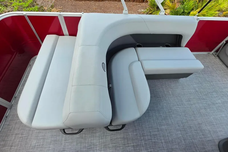 Slide: The Image of 2026 Sun Tracker Party Barge 18 DLX with gray cushioned seating and red paneling. - 15