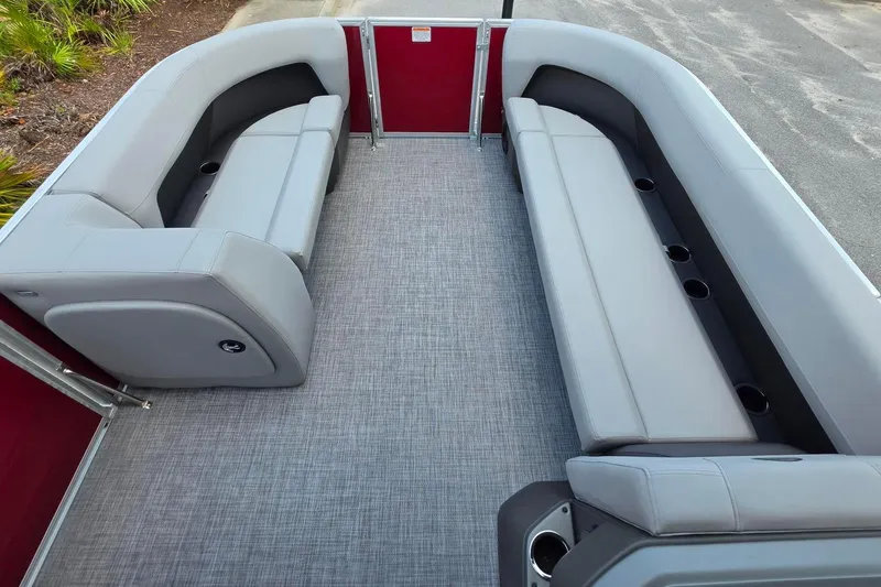 Slide: The Image of 2026 Sun Tracker Party Barge 18 DLX interior with gray seating and cup holders. - 16