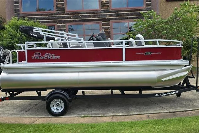 The Image of 2026 Sun Tracker Bass Buggy 18 DLX pontoon boat on trailer, parked outdoors. - 0