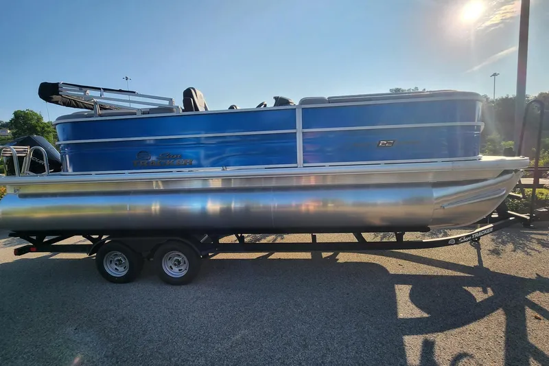 Slide: The Image of 2026 Sun Tracker Party Barge 22 XP3 pontoon boat on trailer in sunlight. - 1