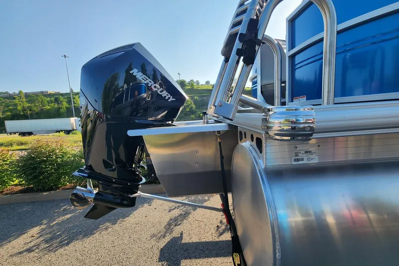 Slide: The Image of 2026 Sun Tracker Party Barge 22 XP3 with Mercury outboard motor, parked outdoors. - 3