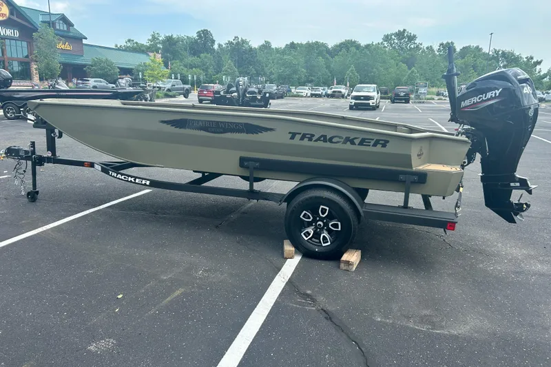 Slide: The Image of 2026 Tracker Grizzly 1650 T Prairie Wings Edition boat on trailer in parking lot. - 11