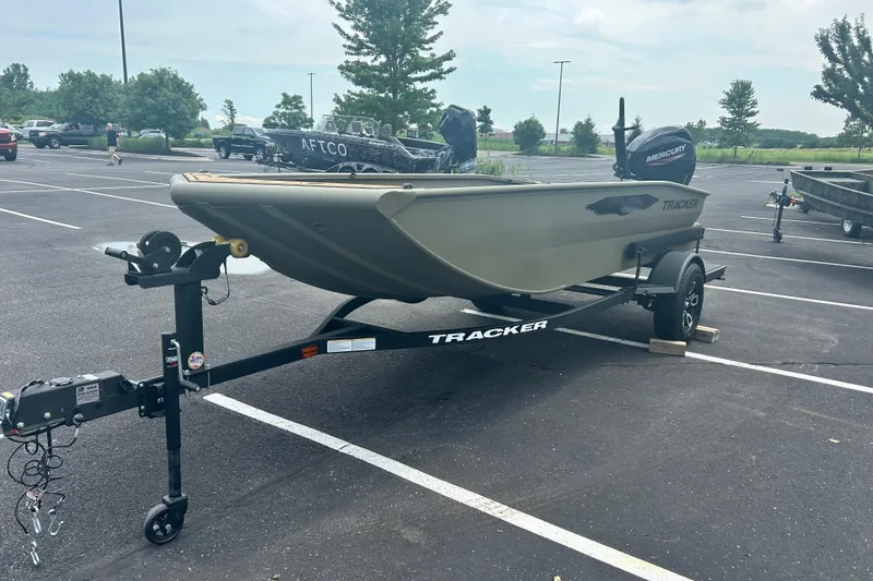 Slide: The Image of 2026 Tracker Grizzly 1650 T Prairie Wings Edition boat on trailer in parking lot. - 12