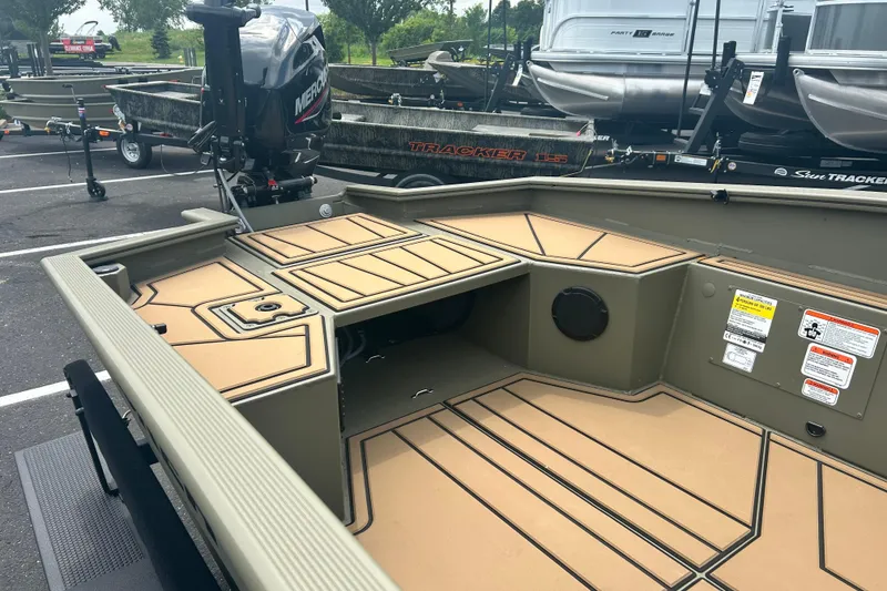 Slide: The Image of 2026 Tracker Grizzly 1650 T Prairie Wings Edition boat interior with Mercury engine in parking lot. - 4