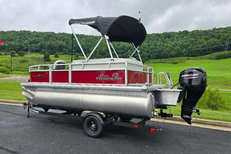 Slide: The Image of 2026 Sun Tracker Bass Buggy 16 XL Select pontoon boat with Mercury engine on trailer. - 3