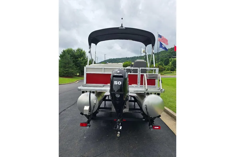Slide: The Image of 2026 Sun Tracker Bass Buggy 16 XL Select pontoon boat with Mercury 50 engine, parked outdoors. - 6