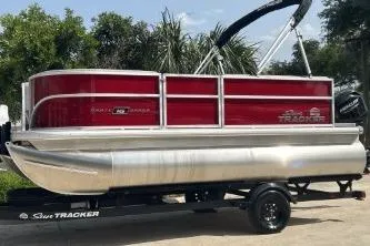 The Image of 2026 Sun Tracker Party Barge 16 DLX pontoon boat on trailer, red and silver design. - 0