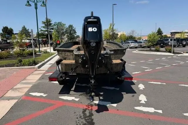 Slide: The Image of 2026 Tracker Grizzly 1756 T Marsh boat with 60 HP motor in parking lot. - 2