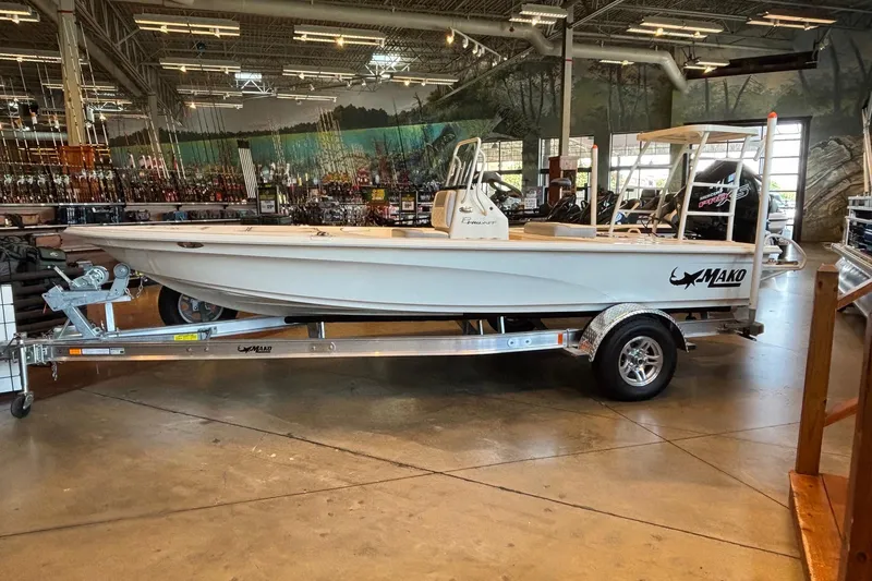 The Image of 2026 Mako 18 Pro Skiff boat displayed indoors on a trailer. - 0