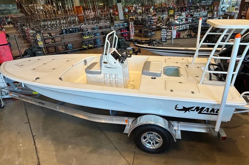 Slide: The Image of 2026 Mako 18 Pro Skiff boat displayed indoors on a trailer. - 1