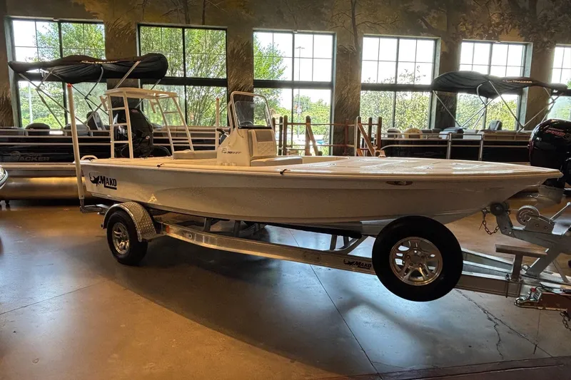 Slide: The Image of 2026 Mako 18 Pro Skiff boat displayed indoors on a trailer. - 3