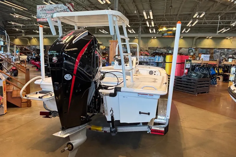 Slide: The Image of 2026 Mako 18 Pro Skiff boat displayed indoors with powerful outboard motor. - 5