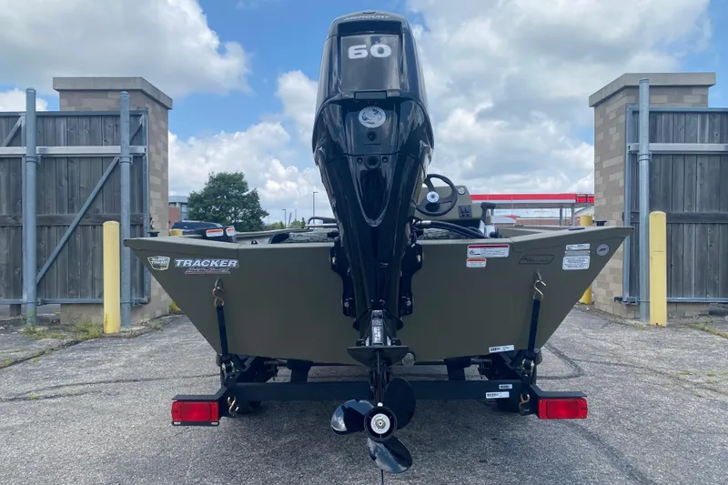 Slide: The Image of 2026 Tracker Grizzly 1754 SC boat with 60 HP motor, parked outdoors. - 5