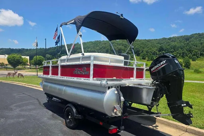 Slide: The Image of 2026 Sun Tracker Bass Buggy 16 XL Select pontoon boat with Mercury engine on trailer. - 4