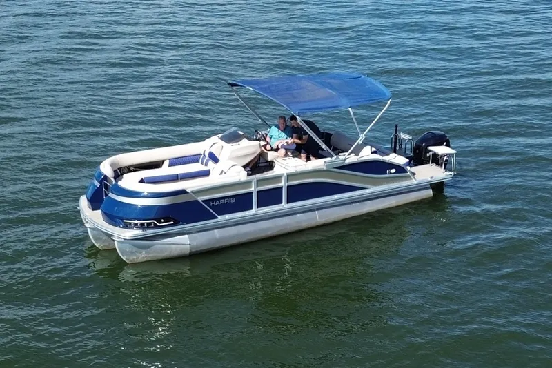 Slide: The Image of 2022 Harris Grand Mariner 250 pontoon boat on water with blue canopy. - 15