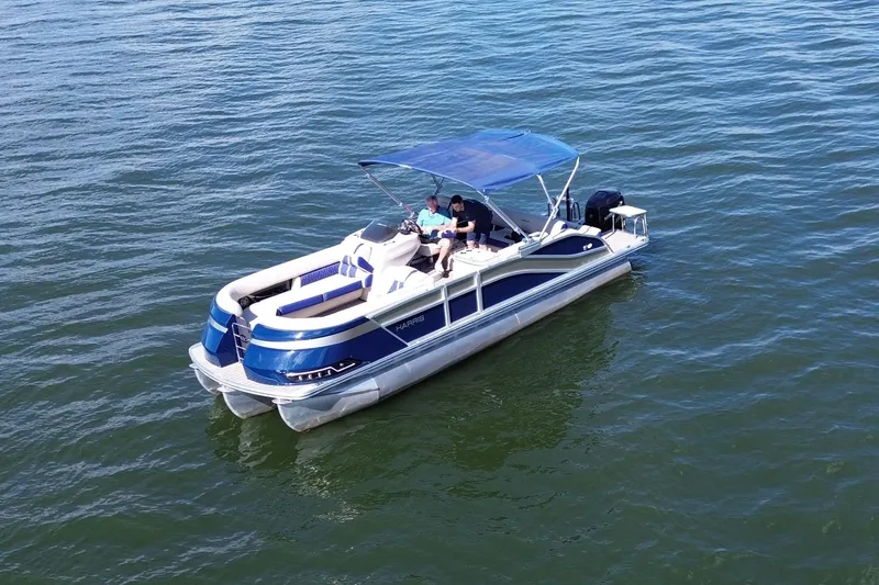 Slide: The Image of 2022 Harris Grand Mariner 250 pontoon boat cruising on open water. - 16